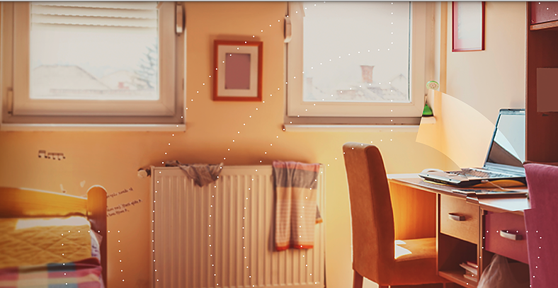 An empty bedroom with an open laptop on a desk